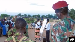 An aid worker [C] talks to Sudanese soldiers and scouts on how to spread the message on HIV/AIDS at an internally displaced camp in Juba, southern Sudan, October 2005. (file photo)