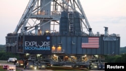 FILE - NASA's Space Launch System mobile launcher rolls on a crawler-transporter for months of testing before the launch of Artemis 1 at the Kennedy Space Center in Cape Canaveral, Florida, June 27, 2019. 