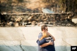 Paul and Erica Mattesich embrace before sifting through rubble at their Ventura, Calif., home, Dec. 6, 2017.