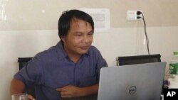 Sai Zaw Thaike, jurnalis foto untuk situs berita independen Myanmar Now, bekerja di kubikel kantornya di Yangon, Myanmar, pada Agustus 2020. (Foto: Myanmar Now via AP)