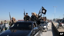 FILE - Members of the so-called Islamic State militant group in Syria.