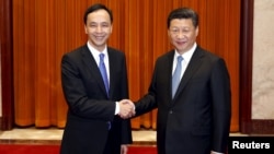 Chairman of Taiwan's ruling Nationalist Kuomintang Party (KMT) Eric Chu, also New Taipei mayor, shakes hands with China's President Xi Jinping as they pose for pictures during their meeting in Beijing, China, May 4, 2015. 