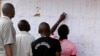 Des électeurs regardent les noms sur un mur au bureau de vote de Kisumu, Kenya, le 6 août 2017.