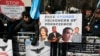 FILE - Uighurs and their supporters rally across the street from United Nations headquarters in New York, March 15, 2018.