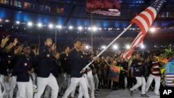 Multi-gold medal winner in swimming Michael Phelps carries the flag of the United States as he leads the U.S. team during the opening ceremony for the 2016 Summer Olympics in Rio de Janeiro, Brazil, Aug. 5, 2016.