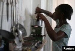 FILE - A Tanzanian woman uses a kerosene stove to prepare a meal in the capital Dar es Salaam, Sept. 28, 2006.