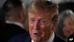 El expresidente Donald Trump habla con sus seguidores durante una parada de campaña en Front Street Pub & Eatery, el 5 de diciembre de 2023, en Davenport, Iowa. 