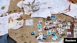 Blood-stained national ID papers and voters' photos are seen on the ground outside a voter identification card center after a suicide attack in Kabul, April 22, 2018.