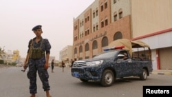 FILE - A pro-Houthi police trooper stands past a patrol vehicle in the Red Sea port city of Hodeidah, Yemen, June 14, 2018. 