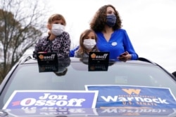 Attendees wait for President-elect Joe Biden to be introduced at a drive-in rally for Georgia Democratic candidates for U.S. Senate Raphael Warnock and Jon Ossoff, in Atlanta, Dec. 15, 2020.