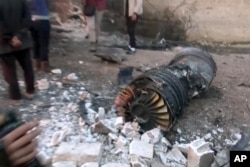 A photo provided by the Ibaa News Agency, the media arm of al-Qaida’s branch in Syria, reportedly shows part of a Russian jet that was shot down by rebel fighters over Idlib province in Syria, Feb. 3, 2018.