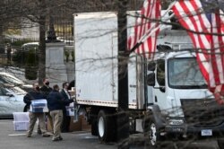 Workers move boxes from the Eisenhower Executive Office Building into a truck on the White House grounds in Washington, U.S., January 14, 2021. (REUTERS/Erin Scott)