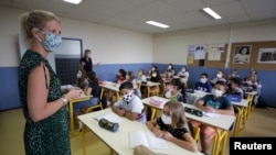 A teacher, wearing a protective face mask, teaches students in a classroom at the College Henri Matisse school in Nice, France, Sept. 1, 2020.