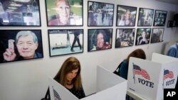 FILE - Voters fill out their ballots at the Los Angeles County Registrar of Voters office in Norwalk, Calif. 