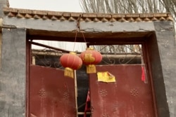 FILE - An "empty house" notice is taped to the door of an abandoned home in Peyzawat County in China's far west Xinjiang region, March 19, 2021.