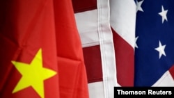 资料照片-在北京举行的中国国际服务贸易洽谈会期间，AICC的展位上的美国和中国国旗。