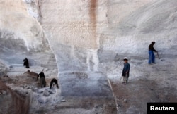 FILE - Men work at Taqcha Khana salt mine in Namak Aab district of Takhar province northeast of Kabul, March 10, 2009.