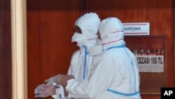 In this photo taken April 5, 2017 and made available April 6, World Health Organization experts work as they take part in an autopsy conducted in a hospital in Adana, Turkey.