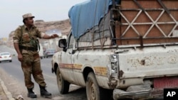 A Yemeni soldier stops a car at a checkpoint in a street leading to the U.S. embassy in Sanaa, Yemen, Aug. 4, 2013.