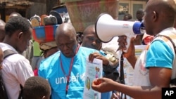 FILE - UNICEF health workers teach people about the Ebola virus and how to prevent infection, in Conakry, Guinea, March 31, 2014..