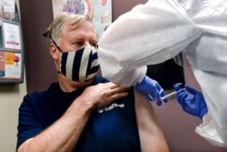 FILE - Wade Bardo of Erin, N.Y., gets an injection as a study of a possible COVID-19 vaccine gets under way in Binghamton, N.Y., July 27, 2020.