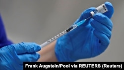 រូបឯកសារ៖ គិលានុបដ្ឋាក​ម្នាក់ ត្រៀម​ចាក់​វ៉ាក់សាំង​បង្ការ​ជំងឺ​កូវីដ១៩ ​របស់​ក្រុមហ៊ុន​ផលិត​វ៉ាក់សាំង Pfizer/BioNTech នៅ​មន្ទីរពេទ្យ Guy ក្នុង​ទីក្រុង​ឡុងដ៍ ចក្រភព​អង់គ្លេស នៅថ្ងៃទី៨ ខែធ្នូ ឆ្នាំ២០២០។ 