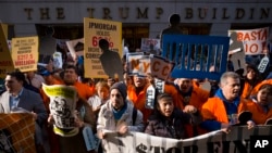 Protesters march on Wall Street, May 1, 2018, in New York. Workers and activists marked May Day with rallies around the world to demand their government address labor issues.