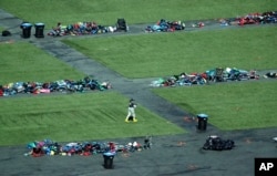 A member of the FBI walks among piles of personal items, Oct. 6, 2017, at the scene of a mass shooting in Las Vegas. Stephen Paddock opened fire on an outdoor music concert on Oct. 1, killing dozens and injuring hundreds.