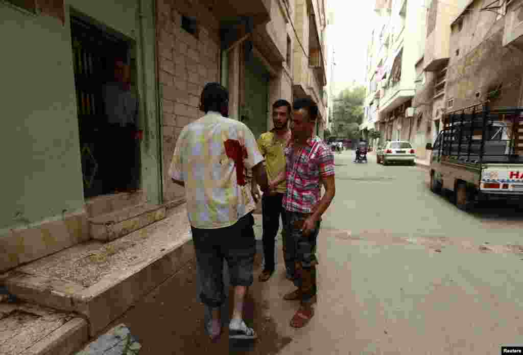 An injured man walks along a street after what activists said was shelling by forces loyal to Syria's President Bashar al-Assad in the al-Myassar neighborhood of Aleppo, Sept. 19, 2013. 