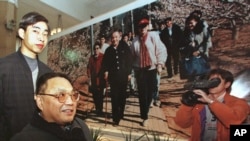 资料照：中国已故领导人邓小平的儿子邓朴方在北京军事博物馆举办的展览中观看了他父亲的一张大照片，由他的妹妹邓琳拍摄。(1998年2月18日)