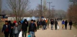 FILE - Migrants walk in Edirne at the Turkish-Greek border, Monday, March 9, 2020.