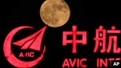FILE - The supermoon, rises over a logo for AVIC or Aviation Industry Corp in Beijing, China, Tuesday, Nov. 15, 2016. 