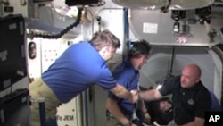 Commander Mark Kelly and the STS-134 crew are welcomed aboard the International Space Station by the Expedition 27 crew, May 18, 2011