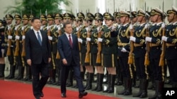 South Korean President Moon Jae-in, center right, and Chinese President Xi Jinping review the Chinese honor guard during a welcoming ceremony at the Great Hall of the People in Beijing, Dec. 14, 2017.