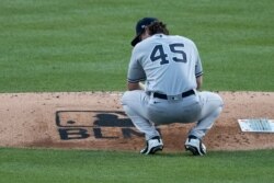 New York Yankees pitcher Gerrit Cole pauses and looks down at the "Black Lives Matter," stenciled on the pitchers mound during the fourth inning of a game against the host Nationals, July 23, 2020.