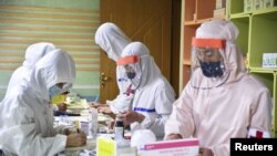 Members of North Korean army supply medicines to residents at a pharmacy amid fears over COVID-19, in Pyongyang, May 18, 2022. (Reuters) 