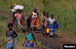 Maria Jofresse, 25, walks with her parents to a camp for the displaced in the aftermath of Cyclone Idai, in John Segredo, near Beira, Mozambique, April 3, 2019.