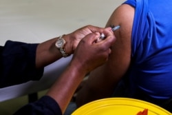 FILE - A healthcare worker administers the Pfizer coronavirus disease (COVID-19) vaccine to a man, amidst the spread of the SARS-CoV-2 variant Omicron, in Johannesburg, South Africa, Dec. 9, 2021.