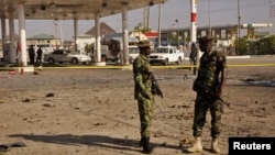 FILE - Members of the military stand at the scene of an explosion near a gas station in Kano, Nigeria, Nov. 15, 2014. 