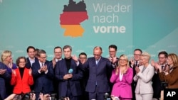 Friedrich Merz, center, candidate of the mainstream conservative Christian Democratic Union party, gestures to supporters at party headquarters in Berlin, Germany, Feb. 23, 2025, after the country's national election. 