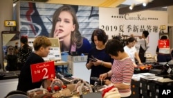 Shoppers browse at a mall in Beijing, Aug. 2, 2019. President Donald Trump intensified pressure on China to reach a trade deal by saying he will impose 10% tariffs Sept. 1 on the remaining $300 billion in Chinese imports he hasn't already taxed.