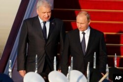 Russian President Vladimir Putin, right, arrives at the Beijing Capital International Airport in Beijing, Sept. 2, 2015.