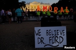 #KremlinAnnex protesters place a sign referring to Christine Blasey Ford, the woman who accused Supreme Court nominee Judge Brett Kavanaugh of a 1982 sexual assault, and spell out the word "AMORAL" on the 66th consecutive day of their demonstration outside the White House, Washington, Sept. 19, 2018.