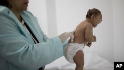 FILE - Lara, who was born with microcephaly, is examined by a neurologist at the Pedro I hospital in Campina Grande, Paraiba state, Brazil, Feb. 12, 2016.