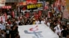 Thousands of people march on a downtown street in Hong Kong Sunday, June 1, 2014, to mark the 25th anniversary of China's bloody crackdown on Tiananmen Square protests on June 4, 1989.