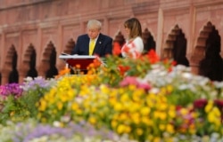 U.S. President Donald Trump signs visitors book as first lady Melania Trump watches during their visit to the Taj Mahal, the 17th century monument to love in Agra, India, Monday, Feb. 24, 2020.