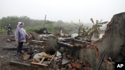 Doan Van Vuon's wife Nguyen Thi Thuong stands by debris of their house after it was destroyed by local authorities and armed forces in Quang Vinh commune, in Vietnam's northern port city of Hai Phong, February 4, 2012.