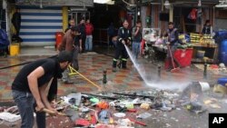 Municipal workers clean up the site of a suicide bombing, one of several explosions that left at least 37 people dead in Baghdad, Feb. 7, 2015.