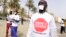 People with a white paper covering their mouth and a t-shirt reading "enough is enough" demonstrate in Dakar on April 22, 2016, against the alleged human rights violations in Gambia.