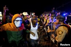 Protesters yell at a police line shortly before shots were fired in a police officer-involved shooting in Ferguson, Missouri, Aug. 9, 2015.